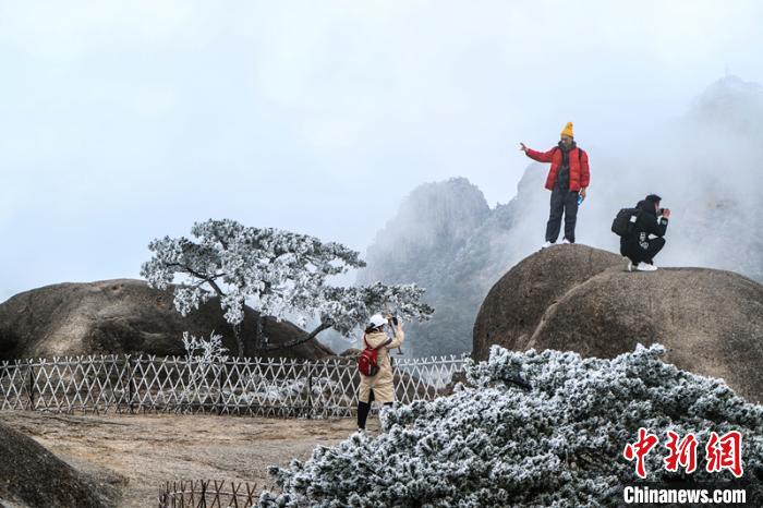 雾凇将黄山奇松怪石装扮得如玉砌银雕，游客在其间拍照留念。　李金刚 摄