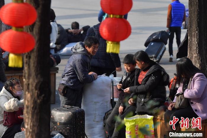 图为返乡的民众在福州火车站广场上候车。　张斌 摄