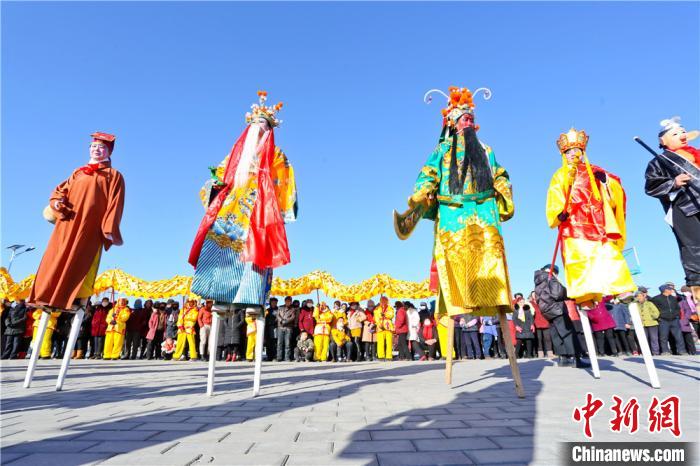 图为社火节目踩高跷。　王将 摄